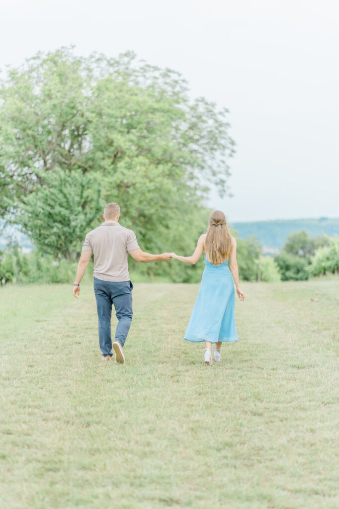 Paarfotos und Hochzeitsfotos in den Weinbergen Süßes Paar in Türkise Kleid und Chino vor einem großen Baum und einem charmanten Steinweg