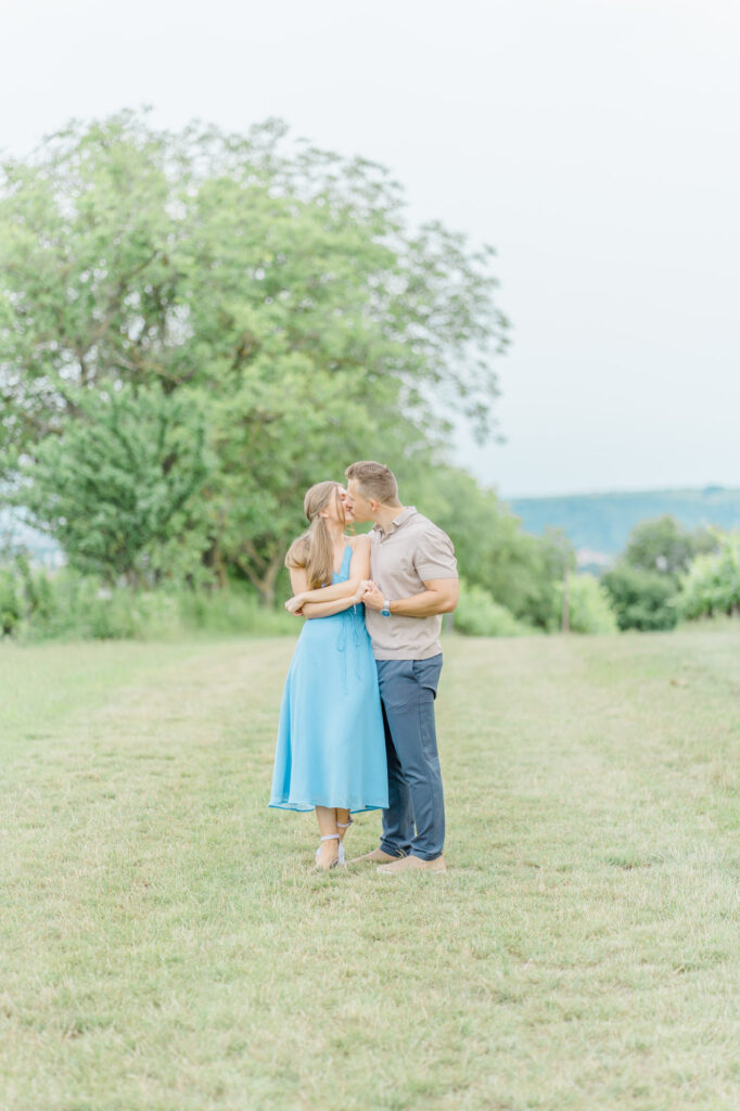 Paarfotos und Hochzeitsfotos in den Weinbergen Süßes Paar in Türkise Kleid und Chino vor einem großen Baum und einem charmanten Steinweg