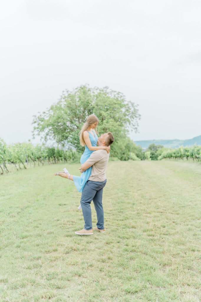Paarfotos und Hochzeitsfotos in den Weinbergen Süßes Paar in Türkise Kleid und Chino vor einem großen Baum und einem charmanten Steinweg