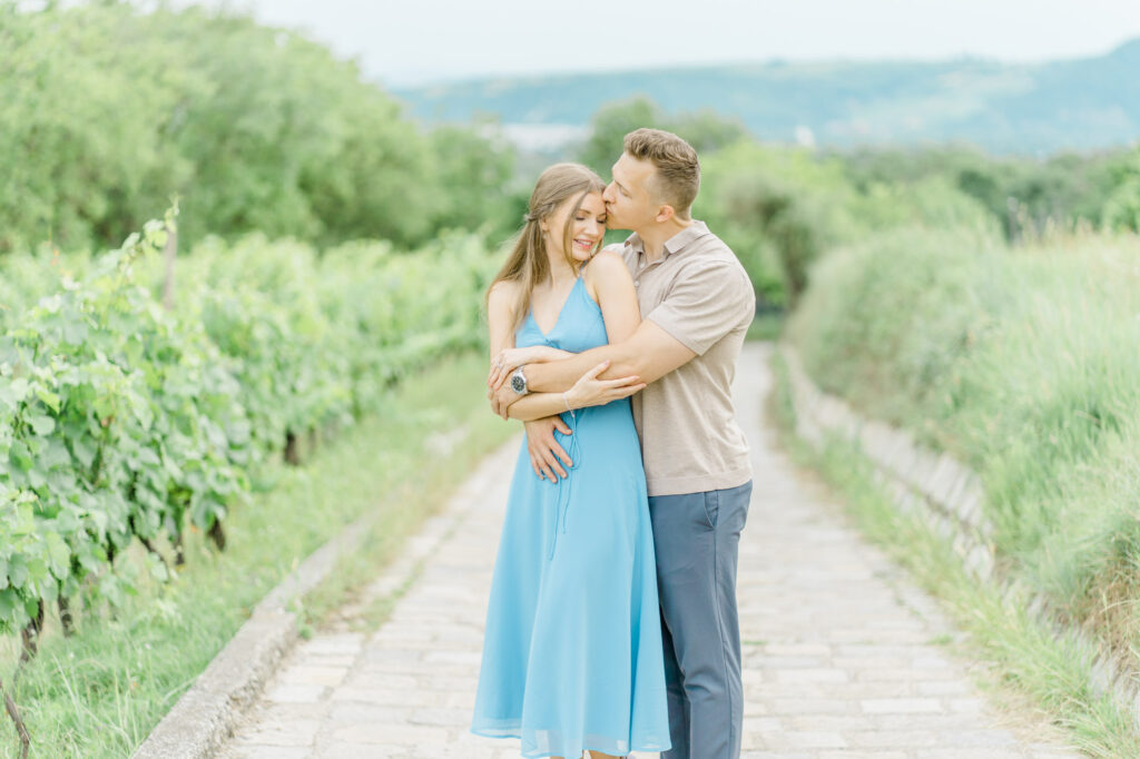 Paarfotos und Hochzeitsfotos in den Weinbergen Süßes Paar in Türkise Kleid und Chino vor einem großen Baum und einem charmanten Steinweg