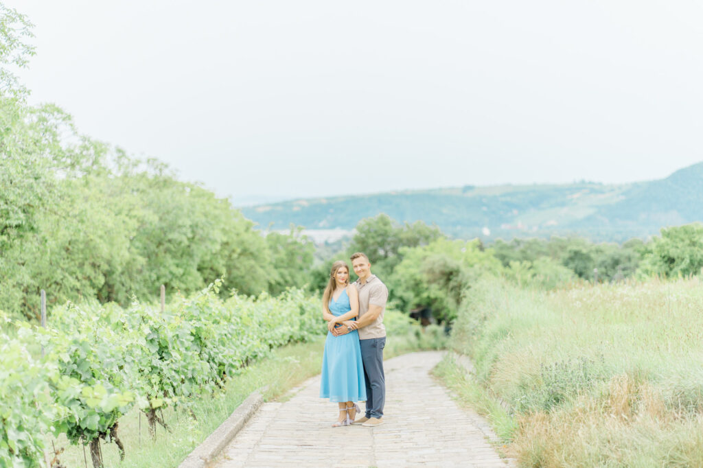 Paarfotos und Hochzeitsfotos in den Weinbergen Süßes Paar in Türkise Kleid und Chino vor einem großen Baum und einem charmanten Steinweg