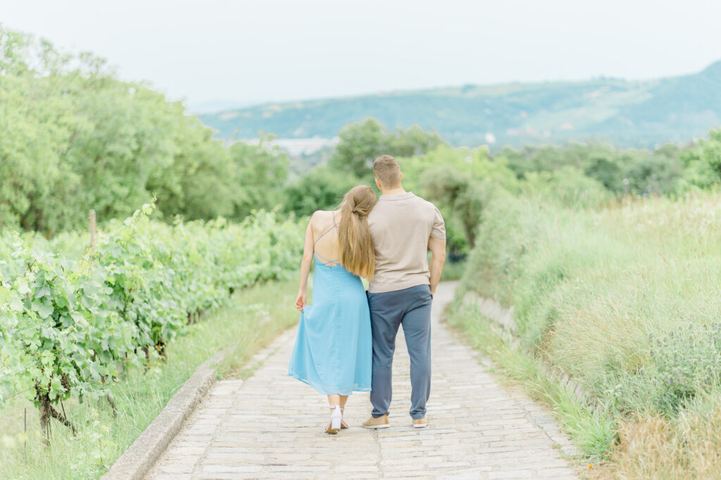 Paarfotos und Hochzeitsfotos in den Weinbergen Süßes Paar in Türkise Kleid und Chino vor einem großen Baum und einem charmanten Steinweg